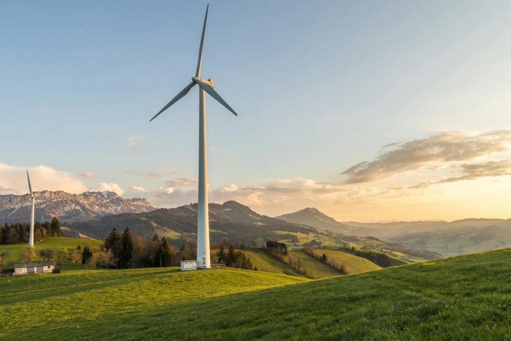 A picture of a wind turbine on a hill in the countryside